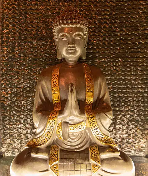 Détail d'une statue de Bouddha dans la salle de détente d'Elaía bien-être.